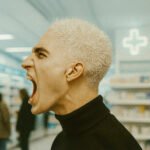 Persoon schreeuwt luid in een winkelomgeving als uitdrukking van frustratie of protest
